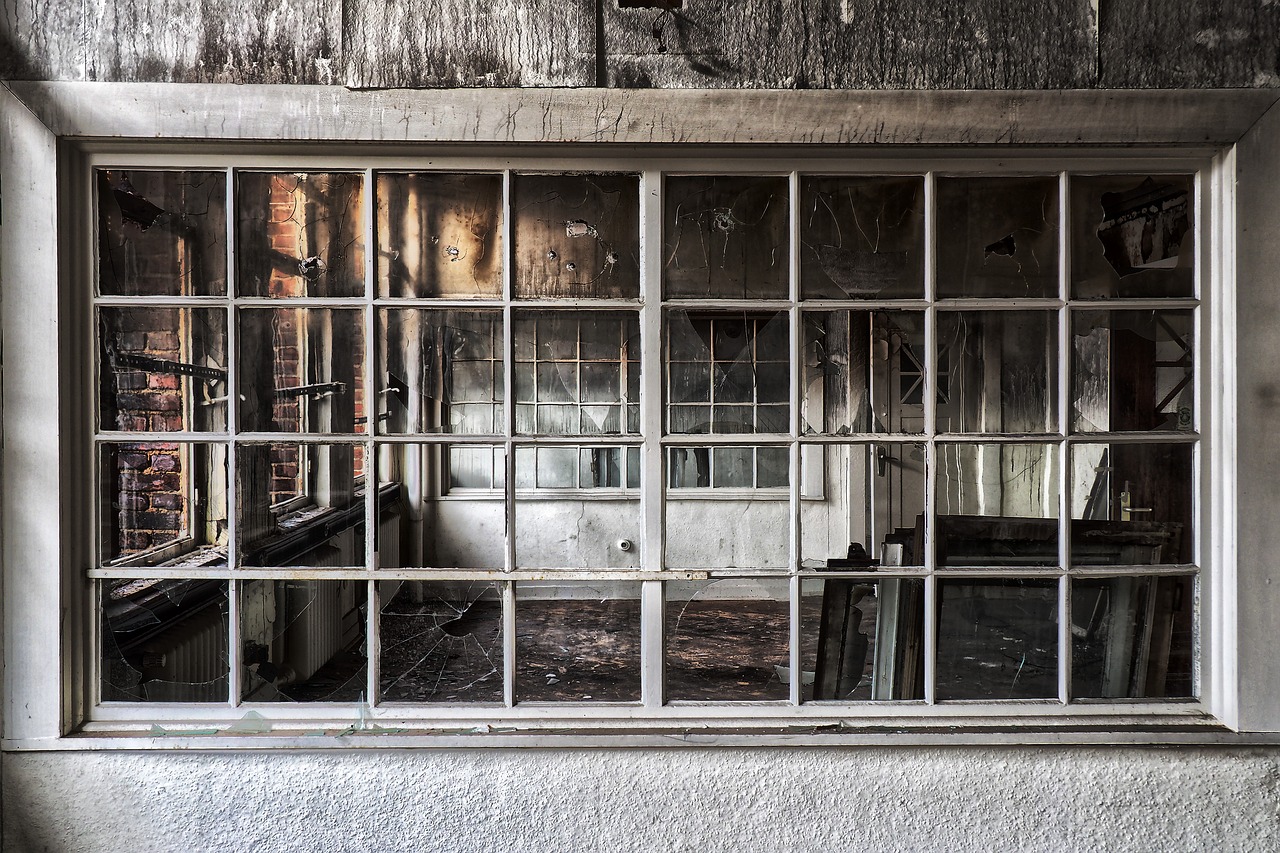 Window Into a Fire Damaged Home With Black and Grey Ash Marks and Broken Furniture