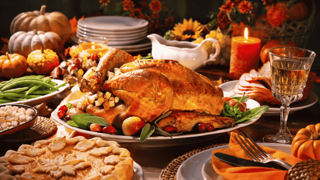 An elaborately decorated thanksgiving dinner table with a lit candle.