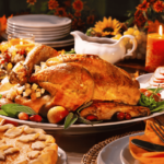 An elaborately decorated thanksgiving dinner table with a lit candle.