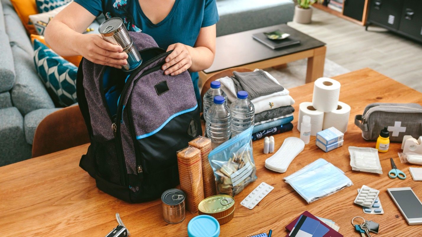 A woman packs a go-bag emergency kit in case of fire.