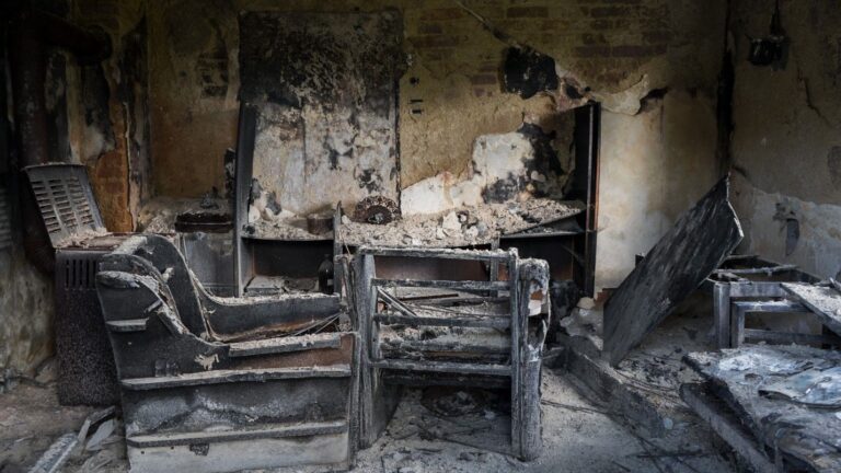 A home destroyed by fire, covered in smoke and soot damage.